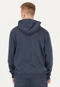 Mörkblå hoodie med framficka och justerbar huva. Har ribbade mudd och nederkant, tillverkad av mjukt, texturerat material.