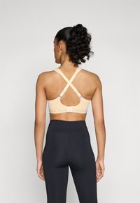 triaction by Triumph ENERGY LITE - Medium support sports bra - passion orange