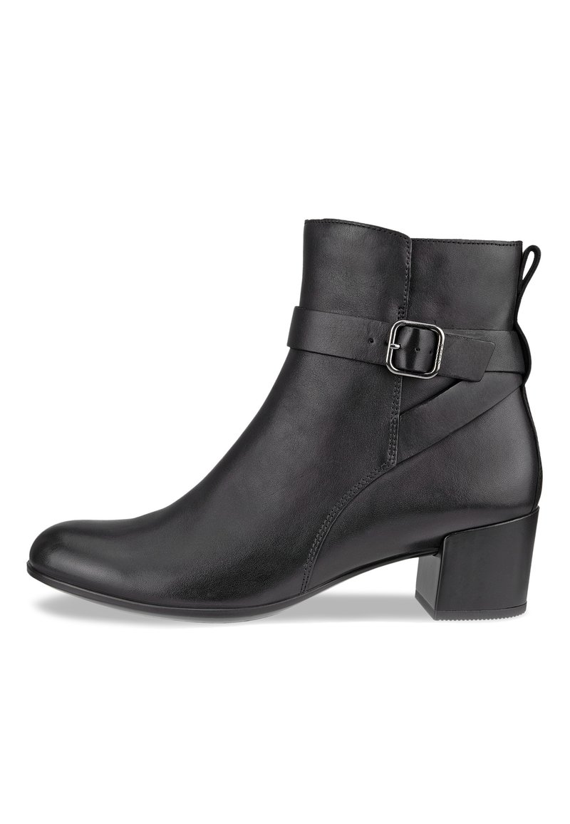 Botín de cuero negro con hebilla lateral, punta redonda y tacón corto, con una textura suave y un diseño elegante.