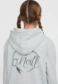 Sivá mikina s kapucňou a kruhovým logom s textom „O'Neill“ a dizajnom pierka na chrbte. Mäkkučká текстúra.