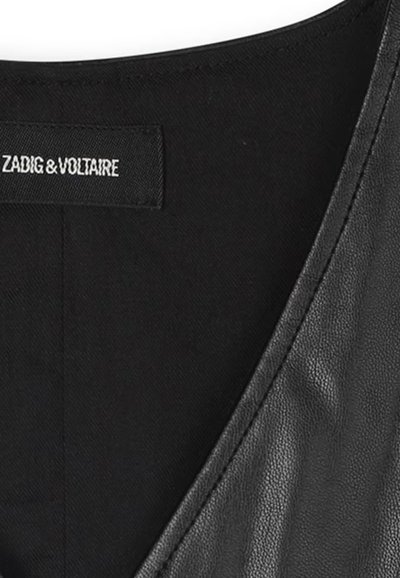 Giaccone in pelle nera con scollatura a V, caratterizzato da cuciture visibili e un'etichetta che recita "ZADIG & VOLTAIRE." Texture liscia.