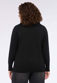 Maglione nero con colletto a coste ampie, maniche lunghe e taglio dritto. Realizzato in morbido tessuto a maglia, presenta una superficie liscia.
