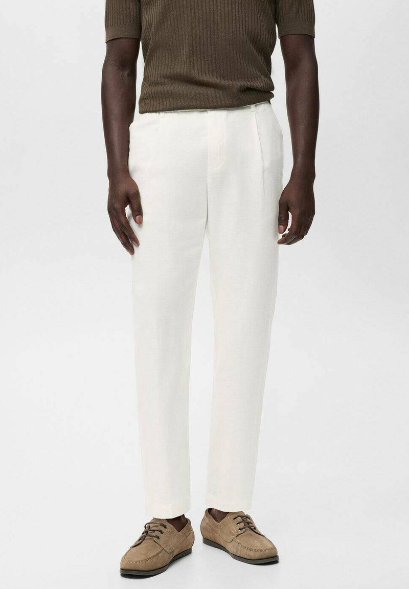 Pantalon en lin blanc à coupe droite, avec des poches latérales. Associé à des chaussures à lacets beiges et un haut court à manches courtes côtelé olive.
