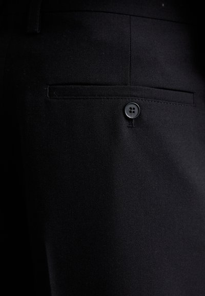 Pantalons noirs taillés avec une texture de tissu lisse, une poche arrière discrète et une fermeture à bouton noir pour un maintien sécurisé.