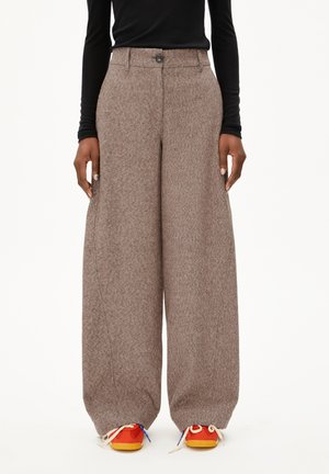 Brown, wide-leg wool trousers with a textured finish, featuring a front button closure and side pockets, paired with colorful sneakers.