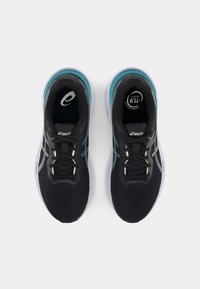 Zwarte sport schoenen met een mesh bovenkant, teal accenten en witte zolen. Kenmerken zijn platte veters en een logo op de tong.
