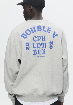 Grijze sweatshirt met blauwe grafische tekst op de achterkant, met de tekst "DOUBLE A CPH LDN BER 2020" in verschillende lettertypen en groottes.