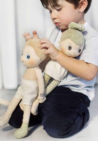 Twee stoffen poppen met geborduurde gezichten. De ene heeft een beige lichaam, gestreepte shirt en witte shorts; de andere heeft een groene bun en gemusterde legging.