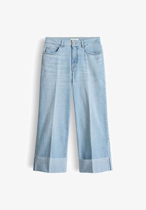 Lichtblauwe wijde jeans met hoge taille, knopen aan de voorkant, zakken en onafgewerkte zoom tegen een witte achtergrond.