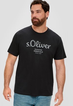 T-shirt en coton noir avec un col rond, arborant le logo "s.Oliver" en gris et le texte "ELEVATED ESSENTIALS SINCE 1969", à manches courtes.