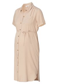 Krátké materské šaty v béžové barvě s límečkem, knoflíkovým zapínáním, náprsní kapsou, nastavitelným páskem a postranními rozparky. Měkká texturovaná tkanina.