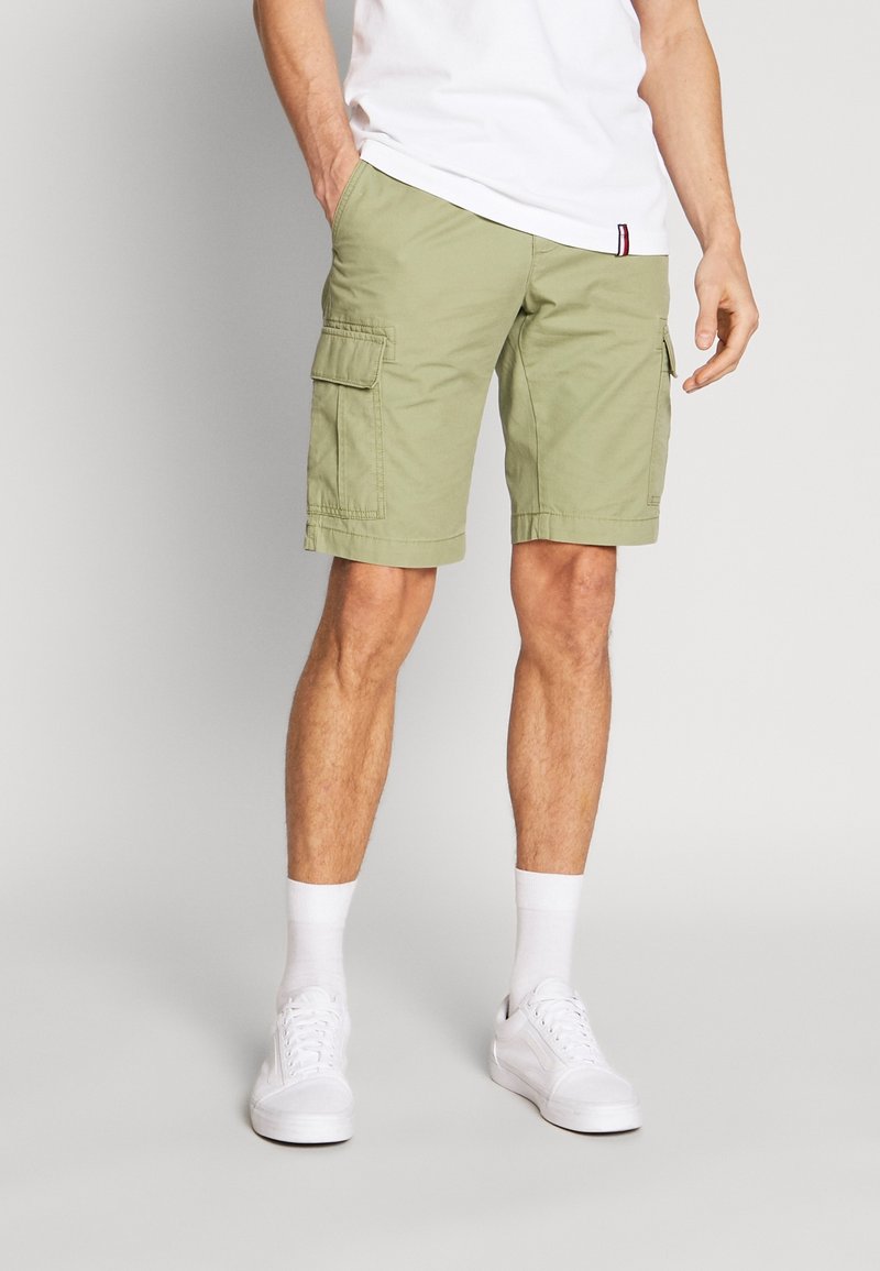 Shorts cargo vert clair en coton, dotés de deux poches cargo latérales, d'un design simple, et s'arrêtant juste au-dessus du genou.