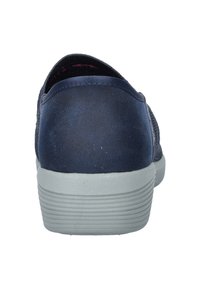 Zapatilla azul marino con parte superior de tela texturizada. Cuenta con una suela de goma gris antideslizante y un talón redondeado. Diseño ligero.