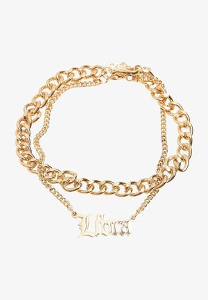 Guldtonad halsband med sammanflätade tjocka och tunna kedjor och en framträdande "Libra"-berlock i ett utsmyckat typsnitt.