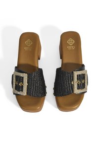 Zwarte geweven sandalen met een dikke hoge hak, voorzien van een grote decoratieve sluiting met een goudaccent en een soepele beige voetbed.