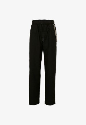 Zwarte broek met rechte pijpen, elastische tailleband, trekkoord en decoratieve zilveren ketting aan de rechterkant.