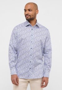 Camicia bianca con motivo floreale blu e viola, colletto alla francese, maniche lunghe e orlo dritto. Realizzata in un tessuto leggero.