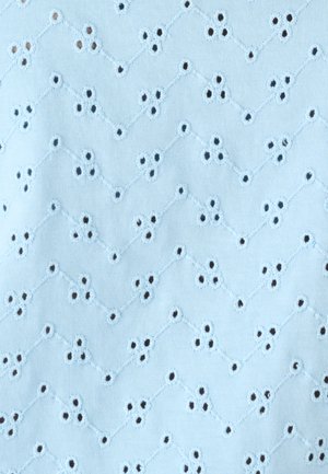 Tissu bleu clair avec des lignes en zigzag brodées et des groupes de trois petits trous d’œillets disposés en motif répétitif.