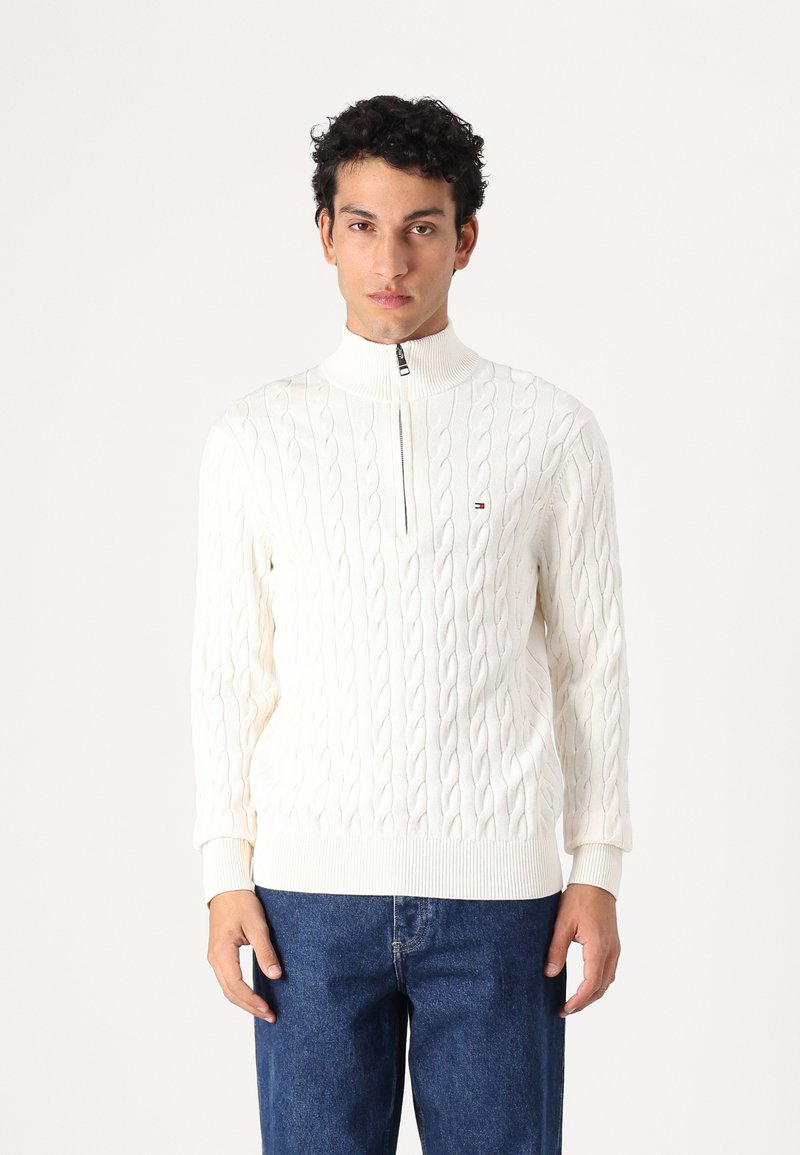 Paarse cable-knit trui met hoge kraag en rits. Zachte textuur, geribbelde manchetten en zoom. Gecombineerd met denim jeans.