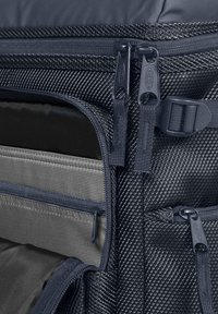 Námořnický texturovaný látkový batoh s dvojitými zipy, několika kapsami a elegantním designem. Obsahuje šedou vnitřní podšívku a nastavitelné popruhy.