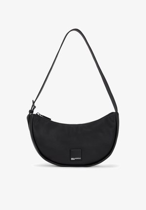 Must musta õlakott, millel on kumer kuju, lukuga sulgemine ja sile tekstuur. Ees on ruudukujuline logo aksessuaar.