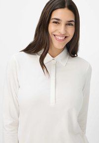 Langärmliges weißes Poloshirt aus glattem Stoff mit einer Vorderleiste und Knopfverschluss, ausgestattet mit einem klassischen Kragen.