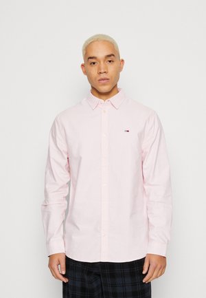 Camisa de botones color rosa claro hecha de algodón, con un cuello clásico y un pequeño logo en el lado izquierdo del pecho, con mangas largas.