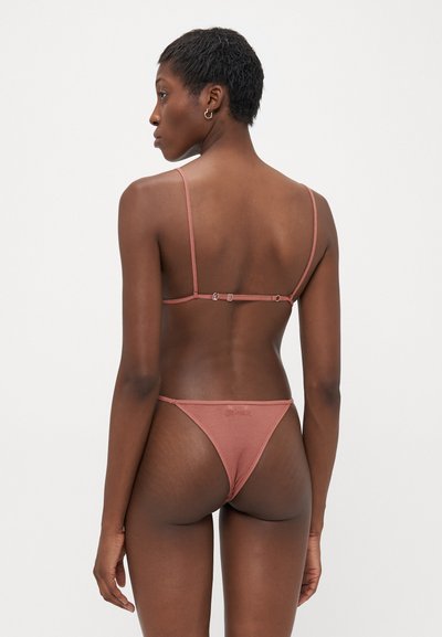 Ribbed bikini w stonowanym różu, z cienkimi regulowanymi ramiączkami i zapięciem na plecach, o minimalnym pokryciu i delikatnym logo.