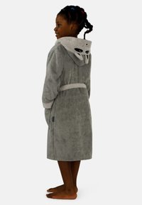 Grau-terry Bademantel mit kontrastierender Kapuze, die Cartoon-Augen zeigt, einem Gürtel und Seitentaschen, kombiniert mit baren Füßen.