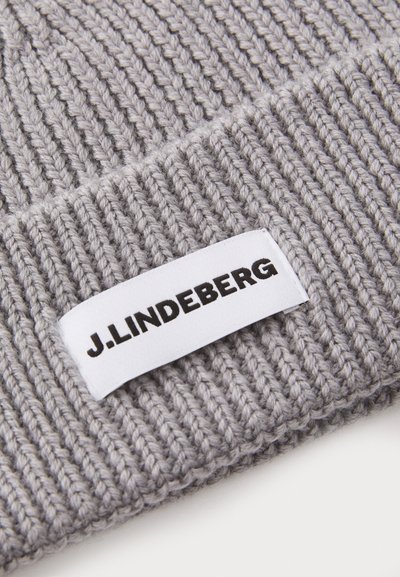 Gray knitted beanie with a ribbed texture and a white fabric tag displaying "J. Lindeberg" in black lettering.
