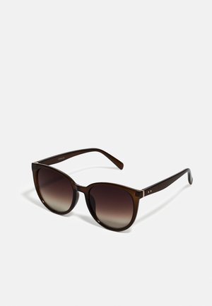 Bruine gradient zonnebril met oversized ronde lenzen, glanzende schildpadachtige frames en slanke armen met subtiele metalen accenten.