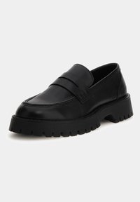 Black leather loafers with a raised front strap and a chunky black rubber sole featuring a textured tread pattern.