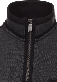 Grijze zip-up jas met een hoge kraag, textuurstof en zwarte accenten. Inclusief een zilveren rits en minimalistische ontwerpdetails.
