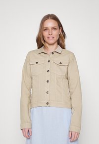 Beige denim takki, jossa on kaulus, etutaskut ja nappisuljenta. Sujuva pinta ja istuva malli pitkillä hihoilla.