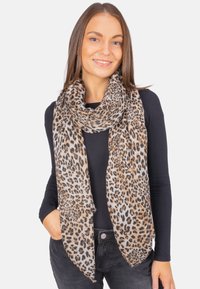 Écharpe en imprimé léopard en tissu doux et léger, comprenant des nuances de beige, marron et noir. Design long et fluide drapé autour du cou.