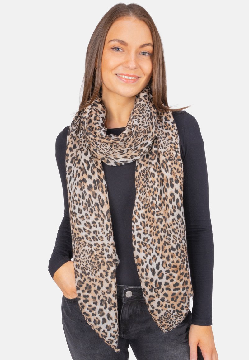 Écharpe en imprimé léopard en tissu doux et léger, comprenant des nuances de beige, marron et noir. Design long et fluide drapé autour du cou.