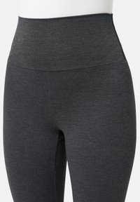 Legginsy z wysokim stanem w ciemnoszarym kolorze, wykonane z elastycznego, miękkiego materiału o gładkiej teksturze, bez widocznych wzorów czy metalowych elementów.