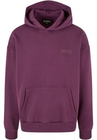 Violetinė kapučino džemperis su priekiu kišene, pūkuotomis rankovėmis ir apatine dalimi, su mažuoju iškilniu "DROPSIZE" logotipu ant krūtinės. Pagamintas iš švelnaus audinio.