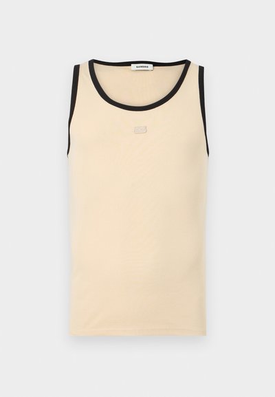 Débardeur beige sans manches avec bordure noire au niveau du col et des emmanchures, arborant un petit logo "23" embossé sur la poitrine.