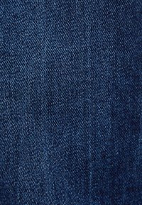 Mörkblå denimtyg med kypertväv. Fint textur med synliga sömmar och subtila färgvariationer över hela tyget.