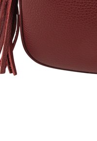 Burgunderrote Ledertasche mit strukturierter Oberfläche, abgerundeten Kanten und langen Lederquasten an der Seite.