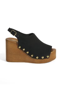 Schwarze Wedge-Sandalette mit offenen Zehen, aus Wildleder, goldenen Nieten entlang der Seite und einem braunen Holz-Plateau. Verstellbarer Knöchelriemen.