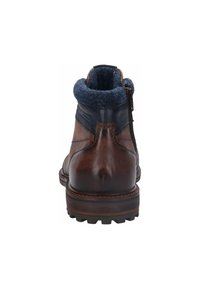 Bruine leren enkellaarzen met een donkerblauwe fleece kraag, ritsen aan de zijkant en een robuuste, getextureerde zool voor grip en ondersteuning.