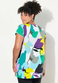 Top de manga corta multicolor con patrones florales abstractos en verde, púrpura, amarillo y azul. Tejido de mezcla de algodón, corte relajado.