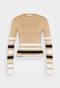 Pull beige à manches longues avec des rayures horizontales blanches, noires et beiges. Il a un col rond et le logo "GUESS" en bas.