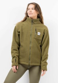 Grüne Fleecejacke mit hohem Kragen, Reißverschluss vorne, Brusttasche und strukturiertem Stoff. Verfügt über ein Logo-Patch auf der Brust.