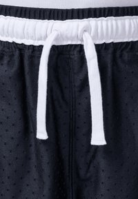 Zwarte sportshorts van gestructureerde stof met een meshpatroon, voorzien van een witte elastische tailleband en trekkoord.