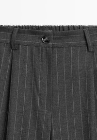 Grijze pantalon met krijtstreep van gestructureerde stof, voorzien van een knoopsluiting aan de voorkant en een geplooid ontwerp. Strakke lijnen en een op maat gemaakte silhouet.