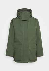 Une parka verte mi-longue en tissu texturé, dotée d'un col haut, d'une capuche ajustable et de deux poches avant.