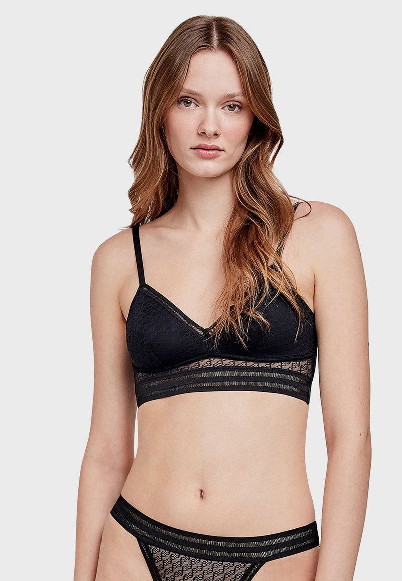 Bralette de encaje negro con ribete de encaje transparente, tirantes ajustables y patrón floral. Acompañado de unas bragas de encaje negro a juego con acentos de banda.